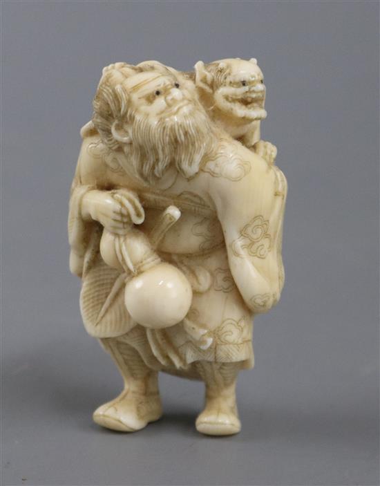 A 19th century carved ivory okimono figure, Shoki and an oni, signed